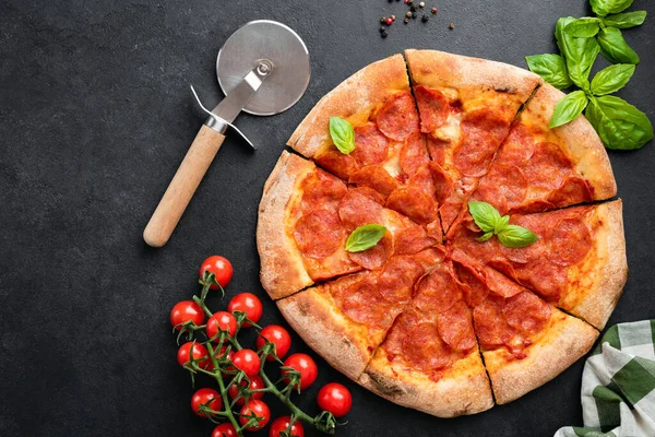 Läcker varm pepperoni pizza på svart betong bakgrund — Stockfoto