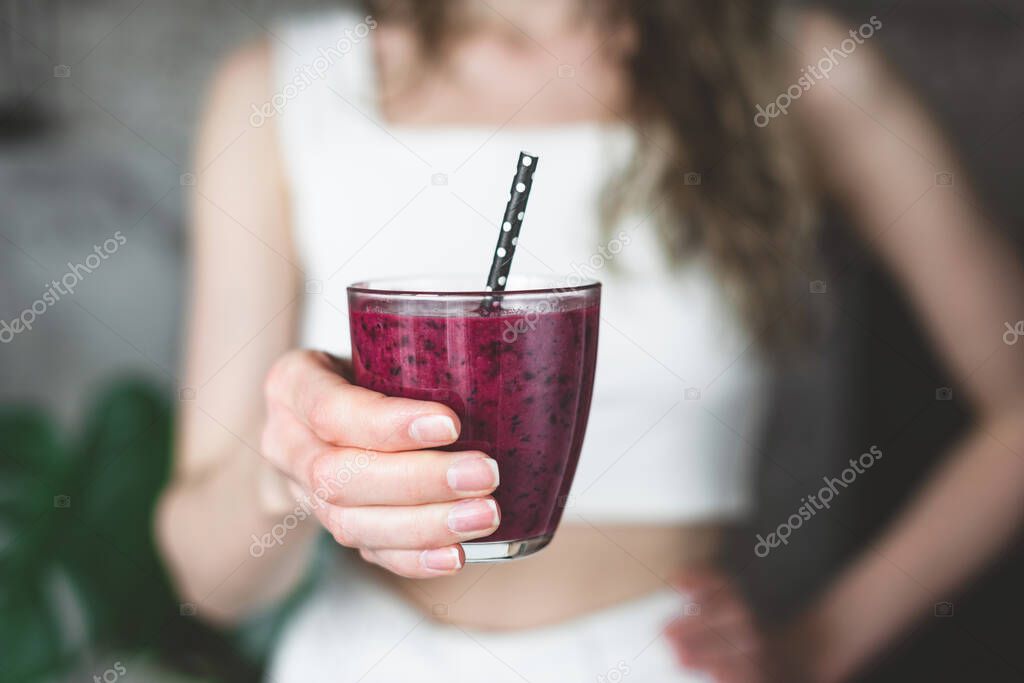 Purple acai smoothie in female hands