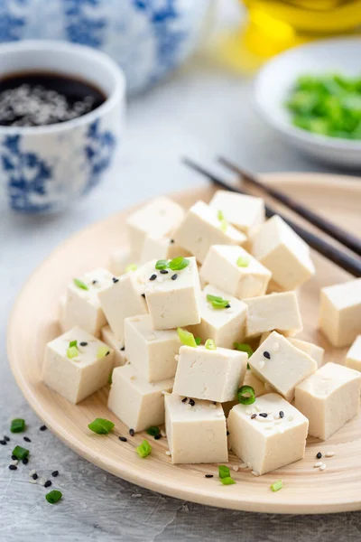 Tofu coupé en cubes sur une plaque de bambou — Photo