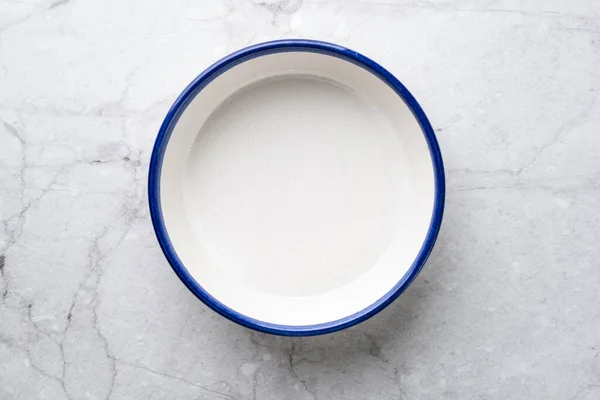 흰 대리석 테이블 배경에 있는 빈 도자기 접시 — 스톡 사진