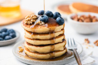 Yaban mersinli gözlemelerin üzerine şurup dökülüyor.