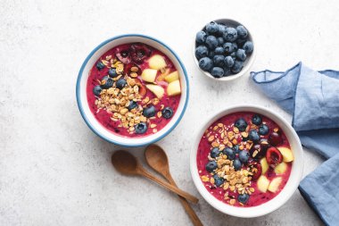 Yaban mersinli ve granollü mor vejetaryen smoothie kasesi.