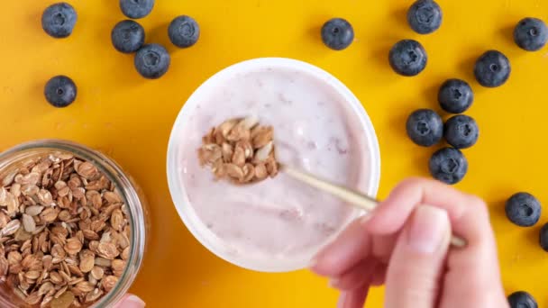 Mangiare Yogurt Mirtilli Con Avena Granola Sfondo Giallo Vista Dall — Video Stock