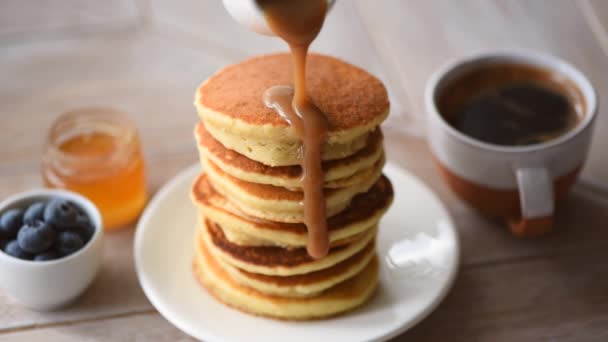 Menuang Saus Karamel Tumpukan Pancake Disajikan Dengan Madu Blueberry Dan — Stok Video