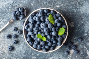 Beton arka planda kasede taze yaban mersini, masa üstü manzaralı. Sağlıklı yaz meyveleri
