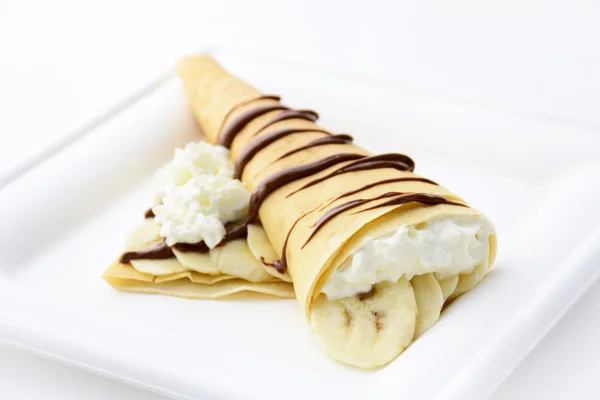 Crepe with banana, whipped cream and chocolate syrup — Stock Photo, Image