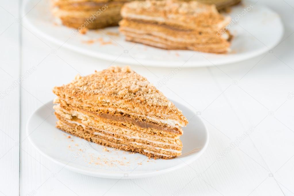 Layered cake with caramel on white plate