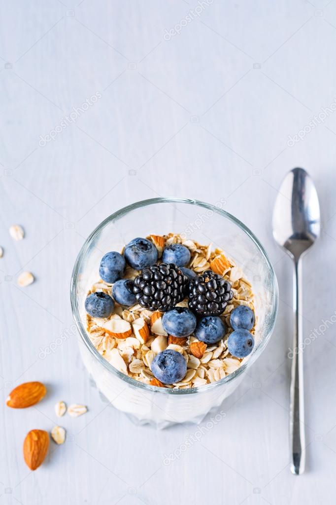 Yogurt with muesli and fresh berries in glass on table. Healthy breakfast food