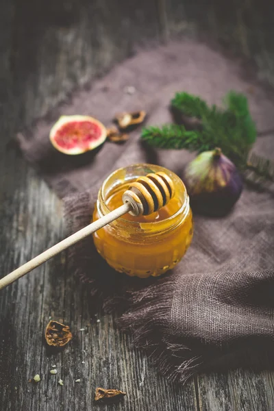 Honey in jar, fruits and nuts on wooden background — Stock Photo, Image