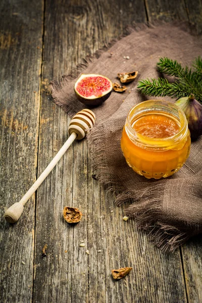 Miele in vaso, frutta e noci su fondo di legno — Foto Stock