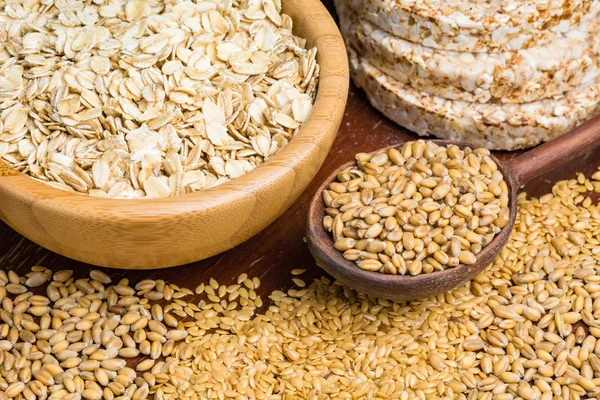 Variety of grains: rolled oats, golden linseeds (flax seeds), whole wheat grains and buckwheat cakes