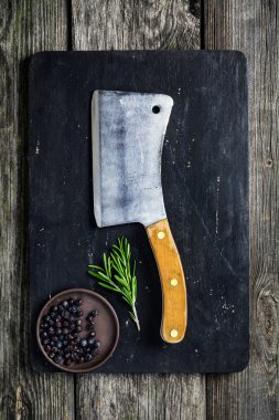 Doğrama tahtası, et satır ve çeşniler koyu ahşap arka plan üzerinde