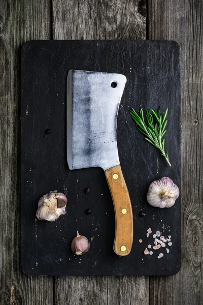 Doğrama tahtası, et satır ve çeşniler koyu ahşap arka plan üzerinde