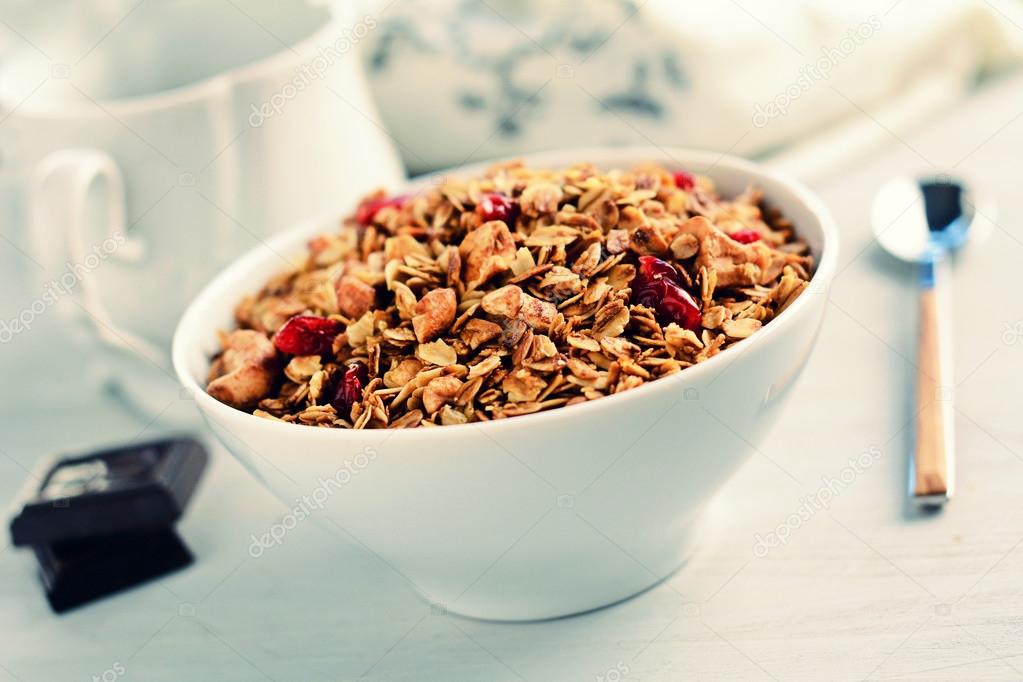Granola (muesli) with nuts and dried fruits in bowl, retro style