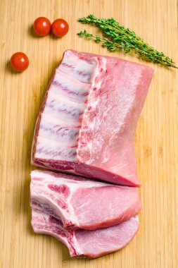 Çiğ et, domuz pirzolası ahşap kesme tahtası üzerinde