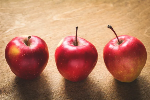 Deliciosas manzanas rojas sobre fondo de madera texturizada — Foto de Stock