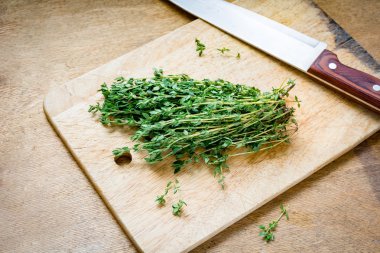Fresh thyme on wooden cutting board