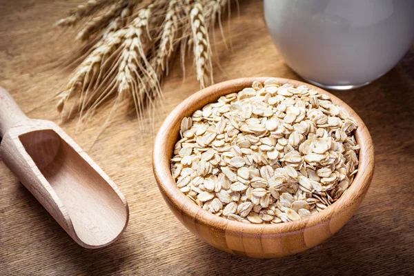 Healthy lifestyle: raw oats in wooden bowl and fresh milk — 스톡 사진
