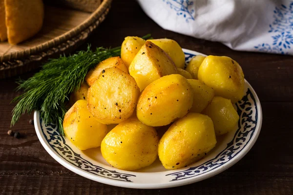 Patate arrosto dorate sul piatto, delizioso contorno — Foto Stock