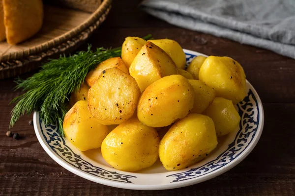 Patatas doradas asadas en plato, delicioso guarnición —  Fotos de Stock