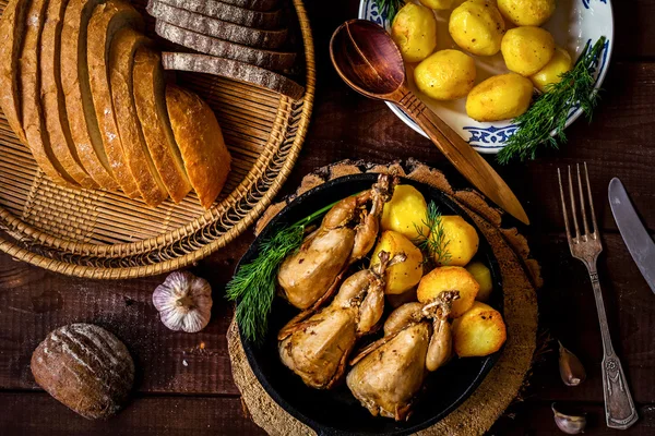 Cena de campo para Navidad. Codornices asadas, patatas enteras, verduras frescas y pan —  Fotos de Stock