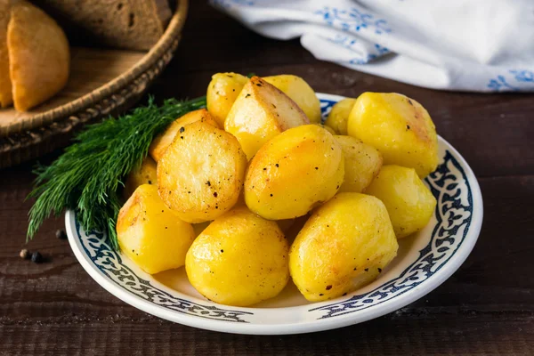 Patatas doradas asadas en plato, delicioso guarnición —  Fotos de Stock