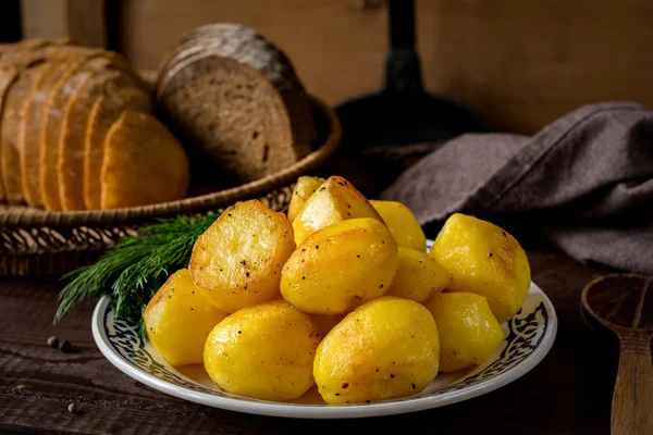Patatas doradas asadas en plato, delicioso guarnición —  Fotos de Stock