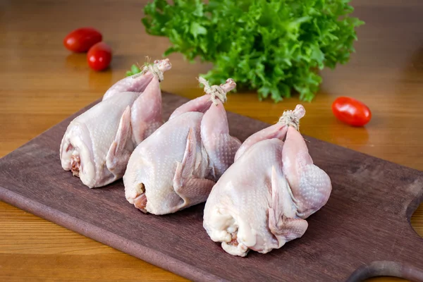 Wodden kesme tahtası üzerinde taze çiğ bıldırcınlar