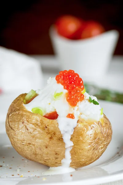 Baked potato with cheese, sour cream and red caviar — Stock Photo, Image