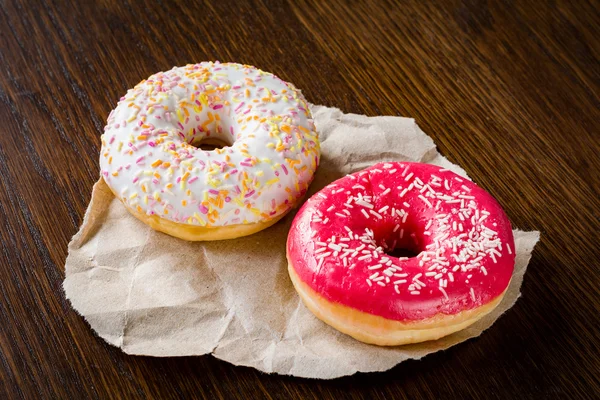 Two donuts on brown wooden table — Stock Photo, Image