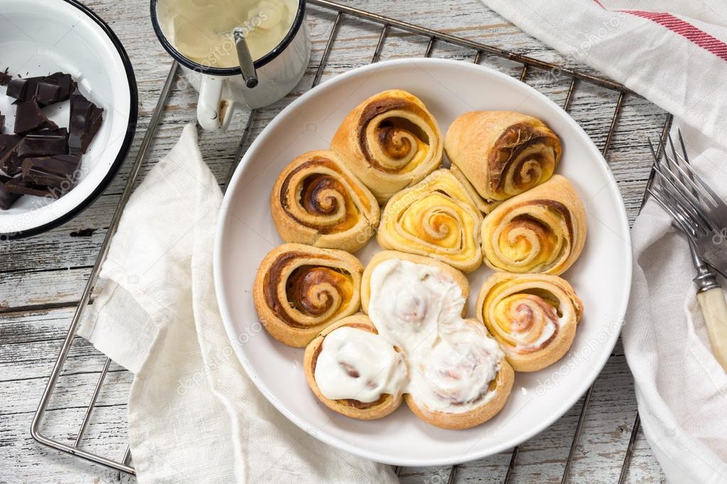 Puff pastry rolls with cream cheese glaze in dish