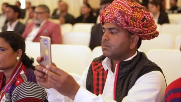 Ein indischer Bauer (Kisan) fotografiert mit seinem Handy einen Rajasthani-Turban (pagadi) in einem Nobelhotel in Delhi — Stockvideo