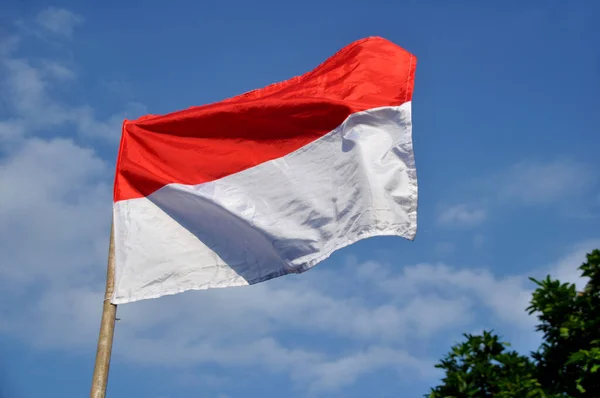 印度尼西亚红白相间的国旗在蓝天的背景下飘扬 — 图库照片