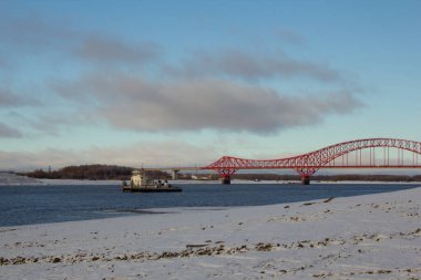 At the end of the navigation period. A tug on the Irtysh river is going to transport a barge with cargo. In late autumn, snow lies on the banks, the river is not frozen yet.