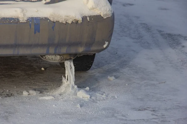 Icicle on the exhaust pipe. In severe frost, moisture condenses and freezes in the exhaust system. Frozen exhaust pipe in severe frost