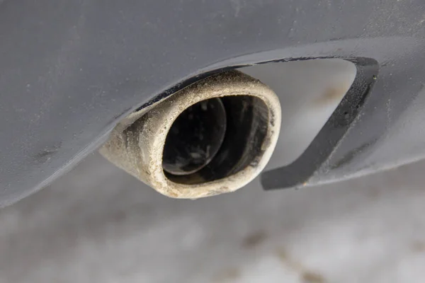 Car exhaust pipe with decorative cap. Dirty exhaust pipe with chrome trim
