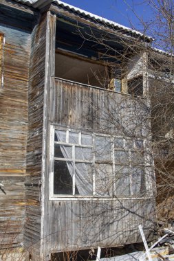 Eski ahşap bir evin ahşap çerçevesinde kırık bir pencere. Terk edilmiş eski bir ev. Boş pencereler. Kuzeyde terk edilmiş ahşap bir bina. Terk edilmiş ve çürüyen ev..