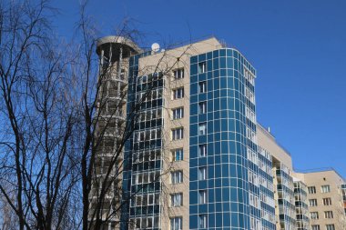 Güzel, modern, çok katlı bir bina. Ağacın yanındaki güzel bina.