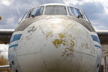 An-24, kısa ve orta menzilli yolcu uçağıdır. Eski bir yolcu gemisi çimlerin üzerinde duruyor..