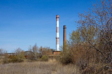 Fabrikası olan sanayi manzarası. Endüstriyel binalar doğada yazılıdır ve endüstriyel bir manzara oluştururlar.