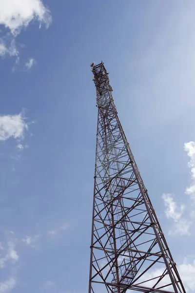 Cell tower. A high tech tower rises into the blue sky