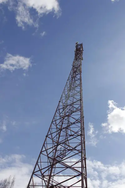 Cell tower. A high tech tower rises into the blue sky