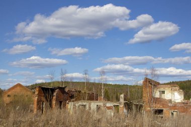 Endüstriyel bir binanın kalıntıları ve Urallar 'da bir tuğla kule. Uzun tuğla kule ve harabeler. Urallar 'daki görkemli harabeler