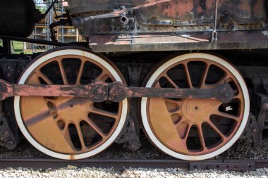 Eski bir buharlı lokomotifin tekerlekleri. Müzeden gelen buharlı bir lokomotifin tekerlekleri raylarda..