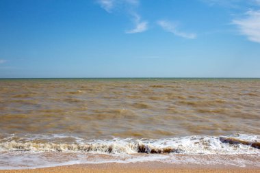 Issız bir sahilde sörf yapmak. Deniz kıyısında güzel bir gün Mavi gökyüzünün altında.