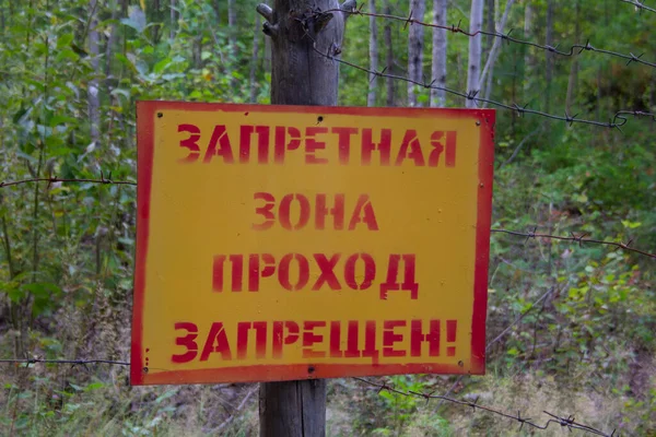 Uyarılmış bölge işareti. Yasak bölgeyi imzalayın. Ormanda dikenli tellere asılı giriş yok..