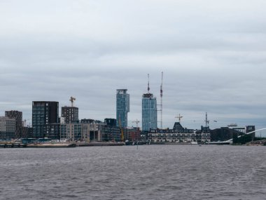 Helsinki 'de inşaat halindeki yeni apartman kuleleri bulutlu bir günde denizden çekildi.