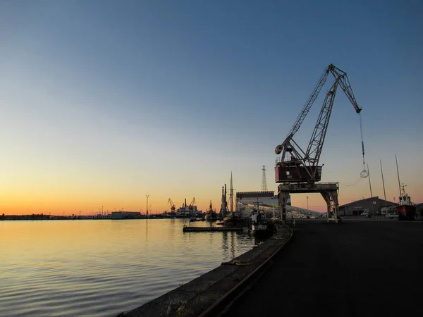 Gün batımında limandaki eski vinç.