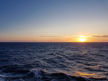 Denizde gün batımı dalgalardan yansıyan güneş ışığı.