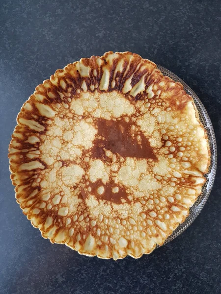 Koyu mutfak tezgahına karşı cam tabakta krep..